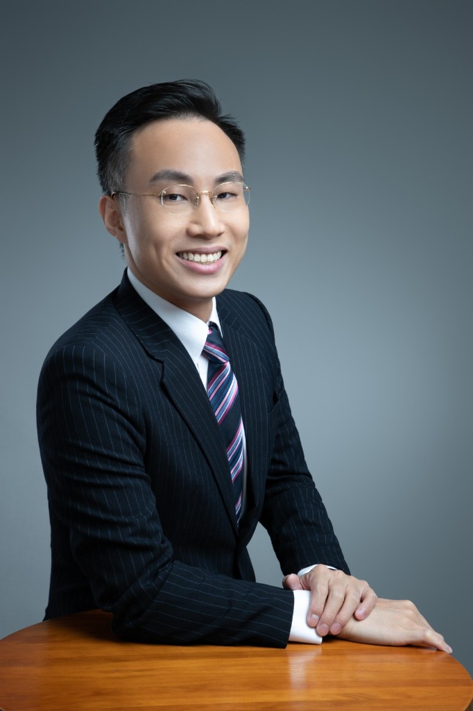 Alvin 坐在書桌前微笑